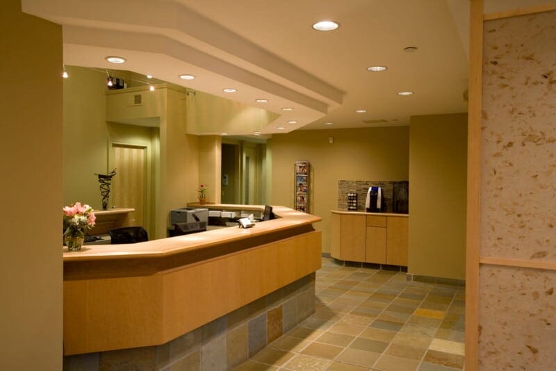 Reception desk area in a modern dental office with warm lighting and wood accents