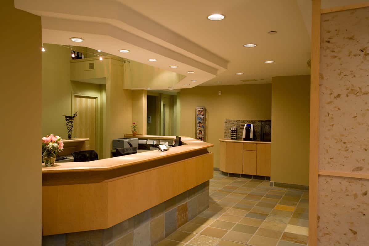 Reception desk area in a modern dental office with warm lighting and wood accents