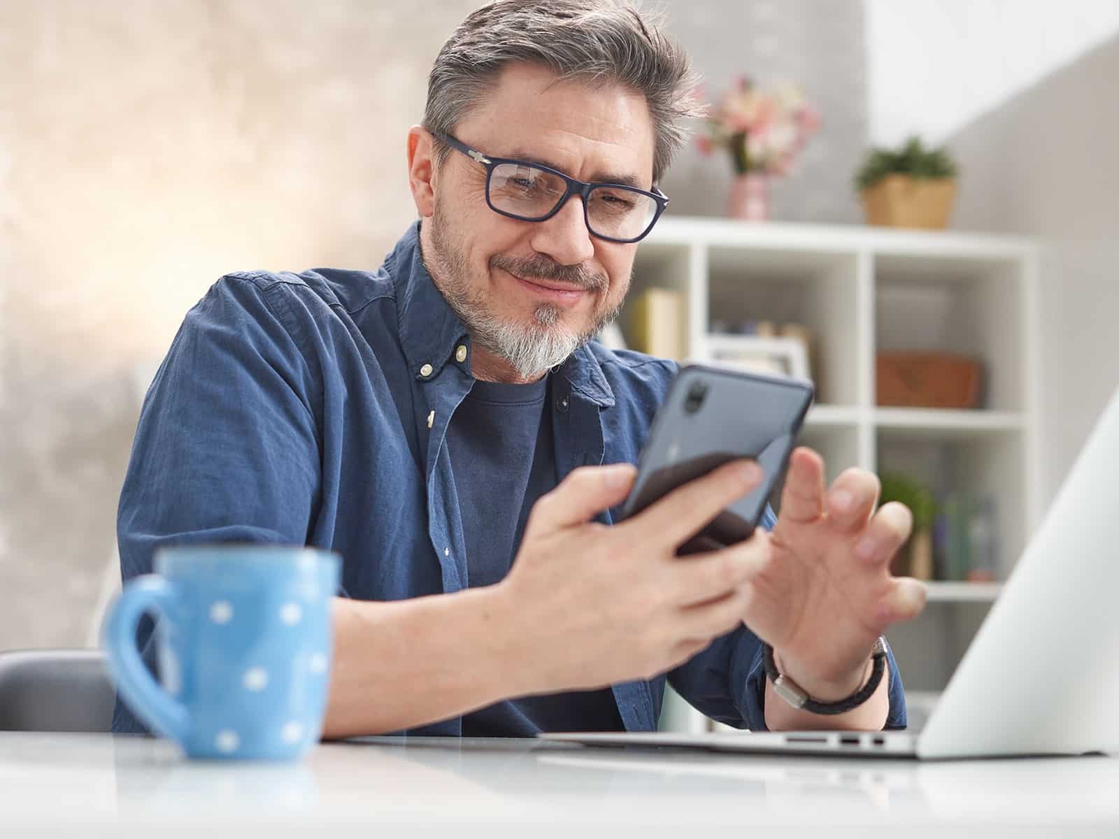 Man smiling and texting on phone